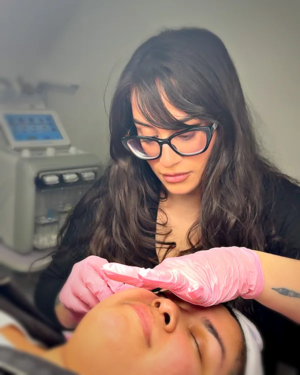 Kyriaki, esthetician and laser technician, treating a client at Glow Up Suite