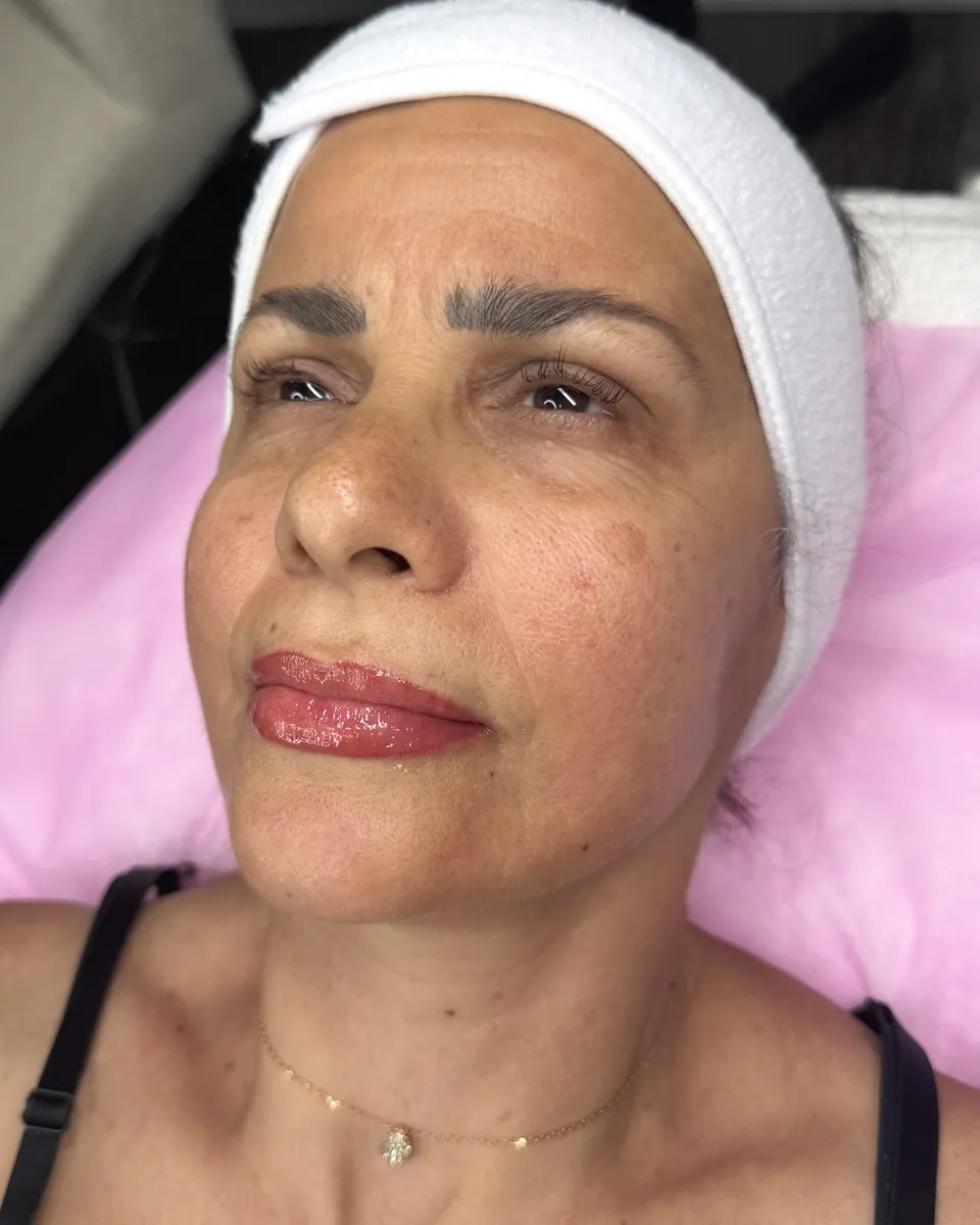 Client with soft, defined lip blush after her treatment at Glow Up Suite